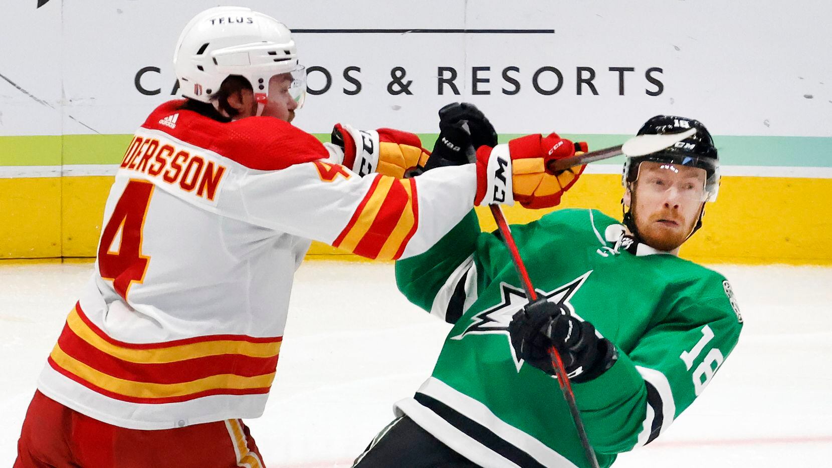Dallas Stars left wing Michael Raffl (18) receives a high stick to the face from Calgary...