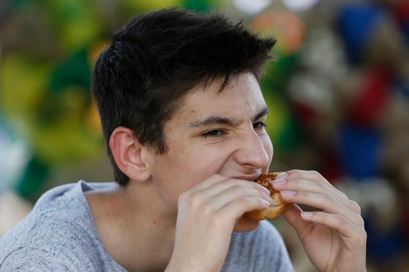 Christian Tindula, 15, of Frisco, sinks his teeth into a grilled cheese sandwich at the...
