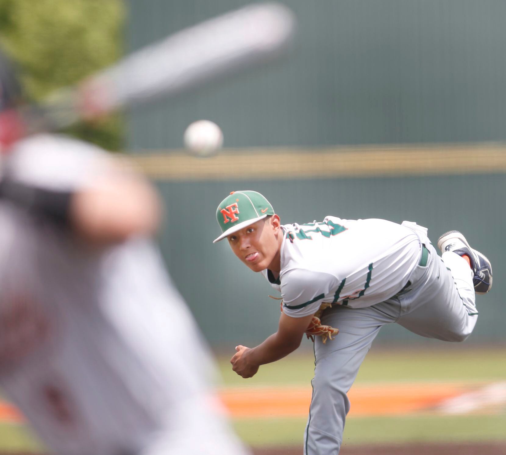 Garland Naaman Forest pitcher Alex Davila (22) delivers a pitch to a Rockwall batter during...