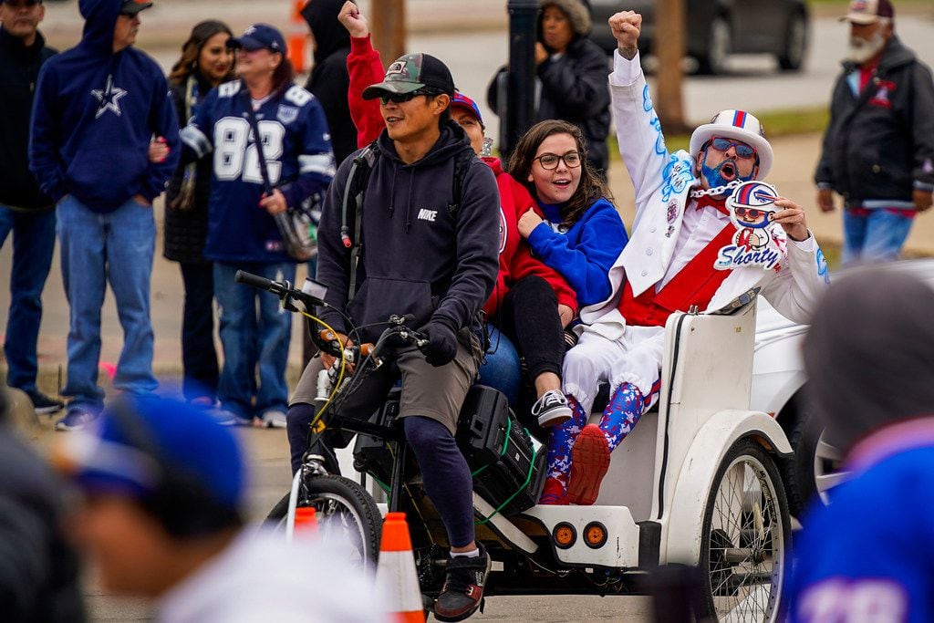 A Buffalo Bills fan cheers from a pedcab as fans head to the stadium before an NFL football...