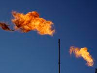 Flares burn off methane and other hydrocarbons at an oil and gas facility in Lenorah, Texas,...