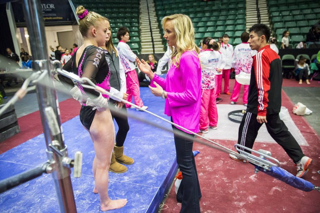 Nastia Liukin, center, talks with gymnast Alyssa Baumann, left, before Baumann competes...