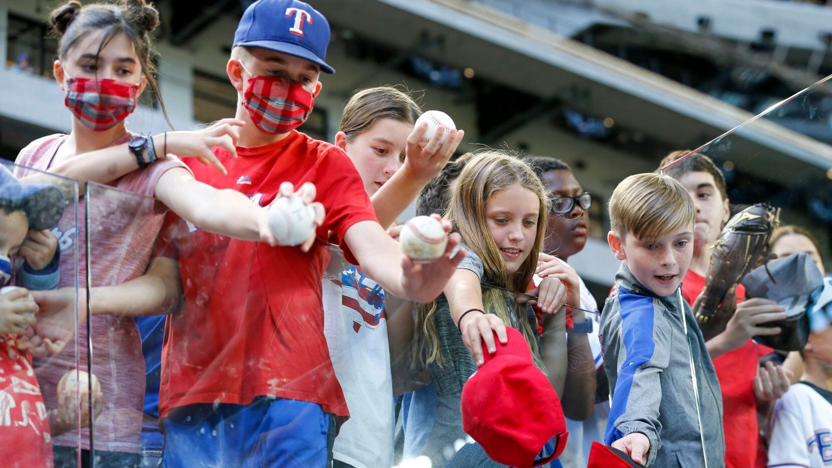 A group of young Texas Rangers fans wait to get autographs from players after the final game...