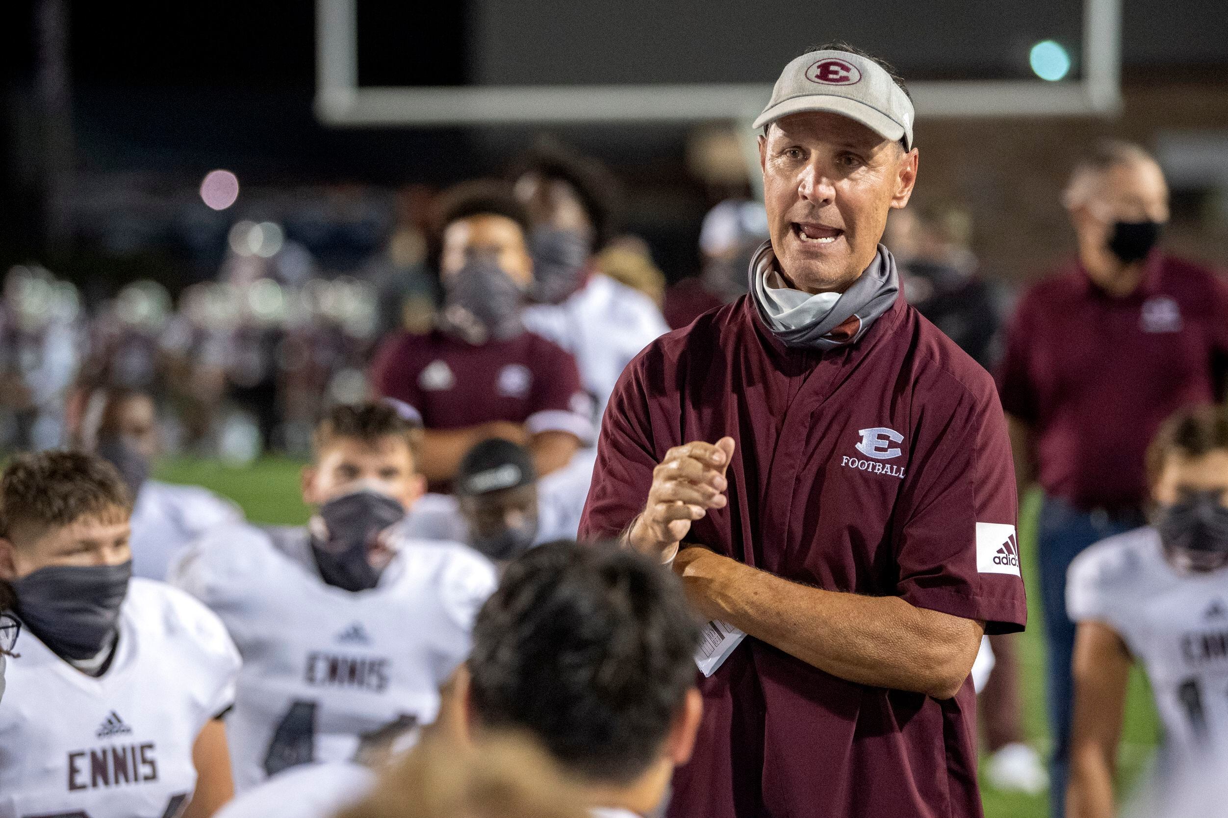 Ennis head coach Sam Harrell talks to his players after their 52-21 win over Red Oak in a...