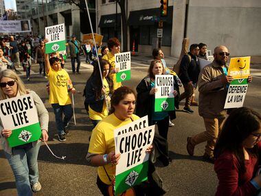 Marchers move through downtown during the North Texas March for Life in Dallas Saturday...