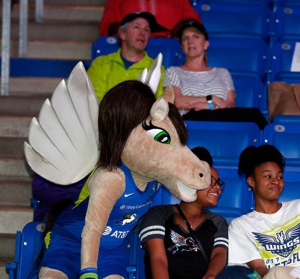 Lightning, the Dallas Wings mascot, takes a photo with fans.