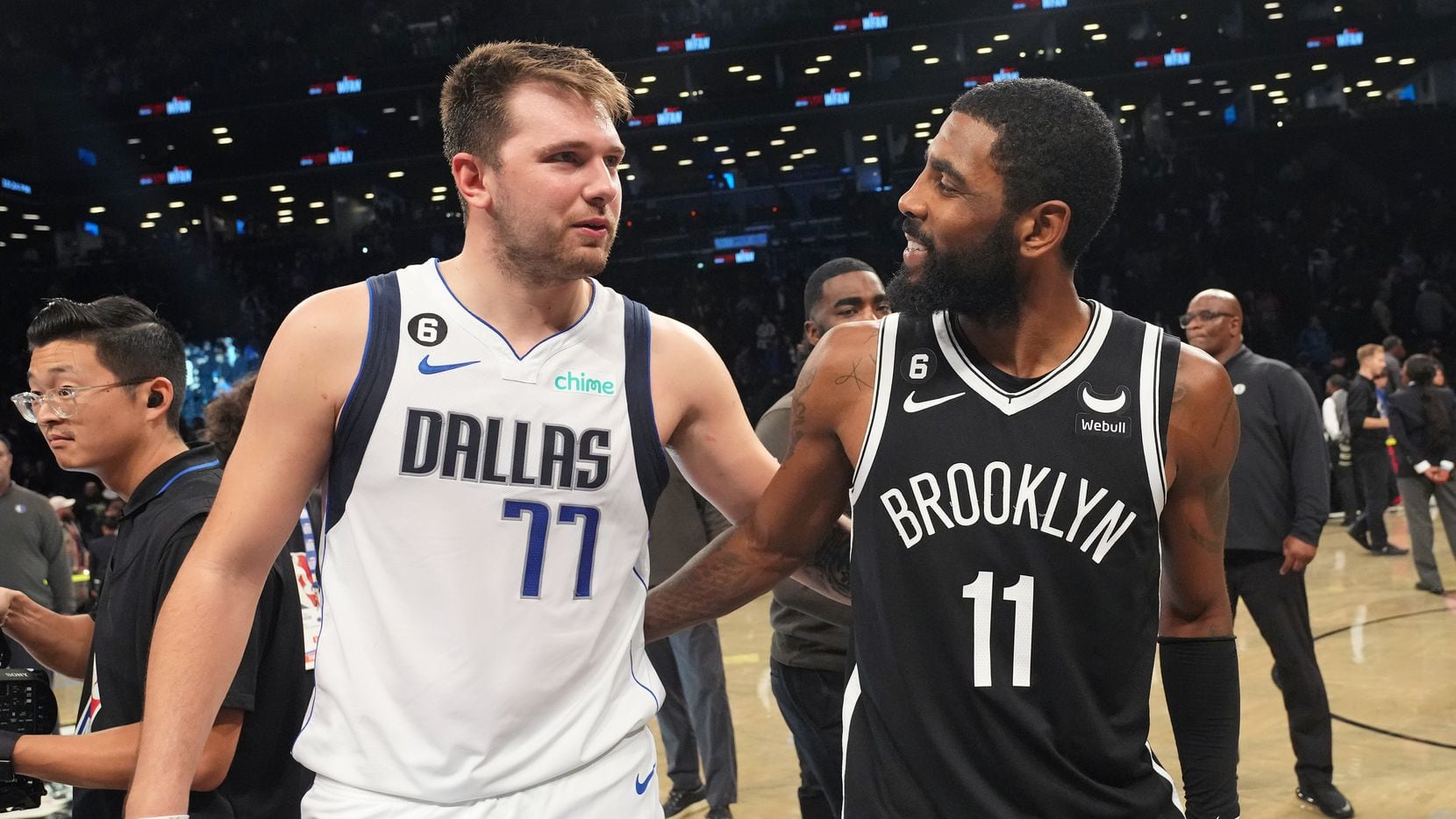 Luka Doncic #77 of the Dallas Mavericks talks to Kyrie Irving #11 of the Brooklyn Nets after...