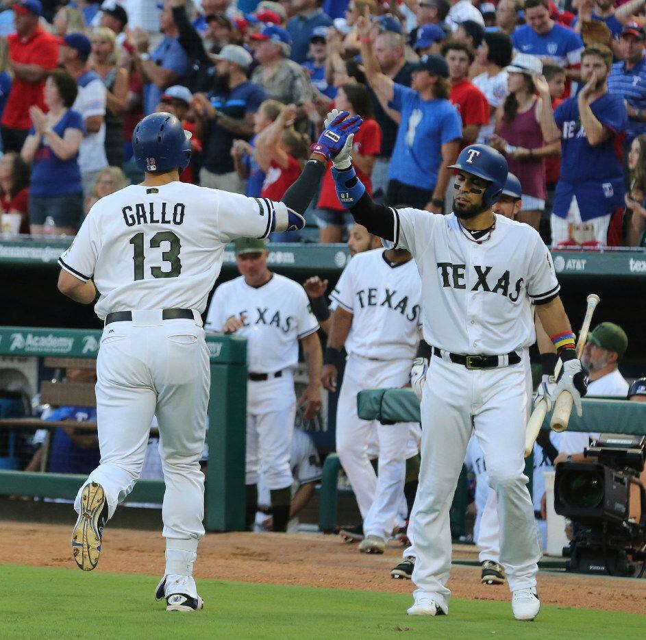 Texas Rangers' Joey Gallo (13) high-fives Robinson Chirinos after a solo home run against...
