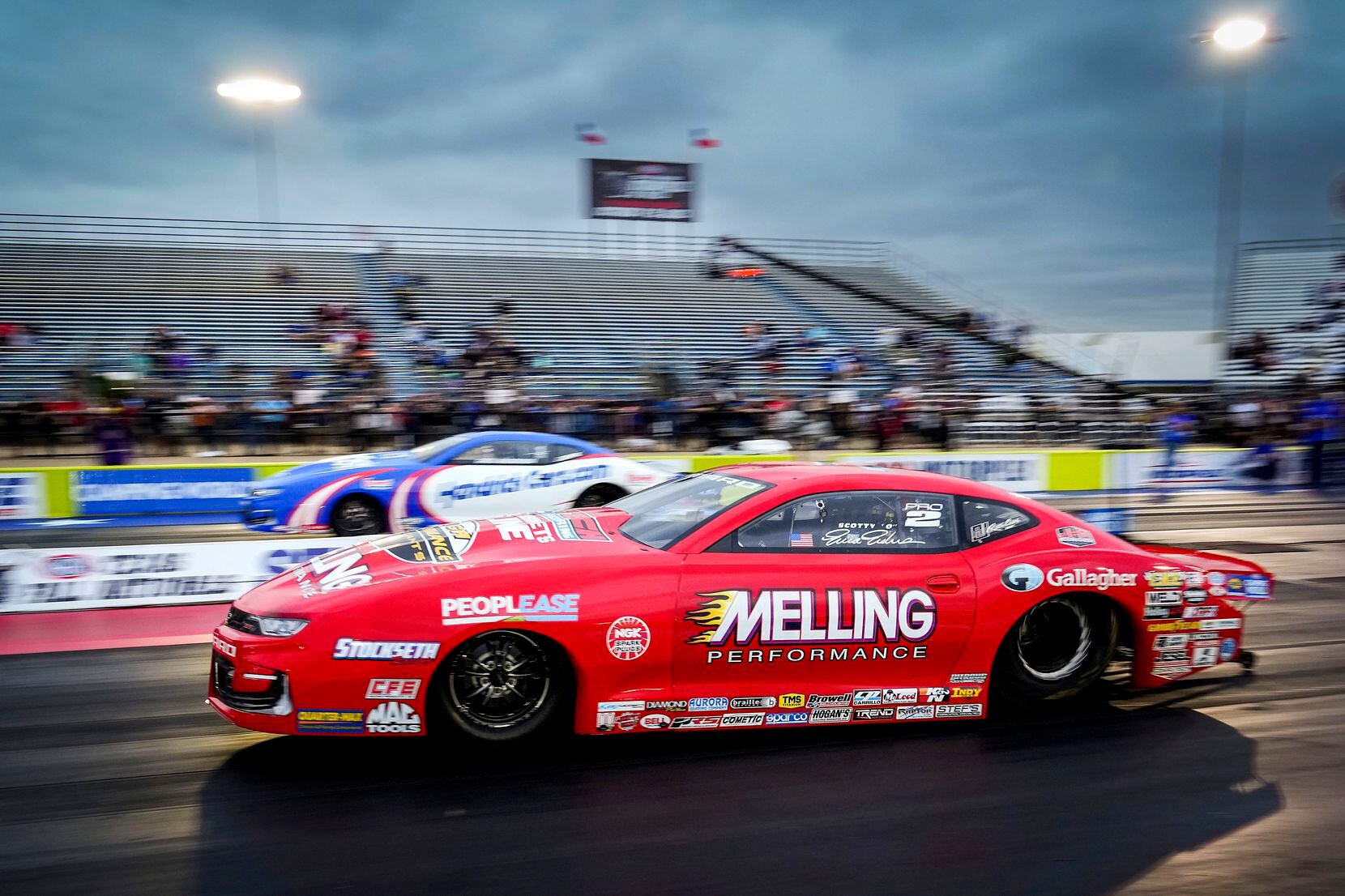 Erica Enders	(front) comes off the line in her Pro Stock victory over Greg Anderson (top) at...