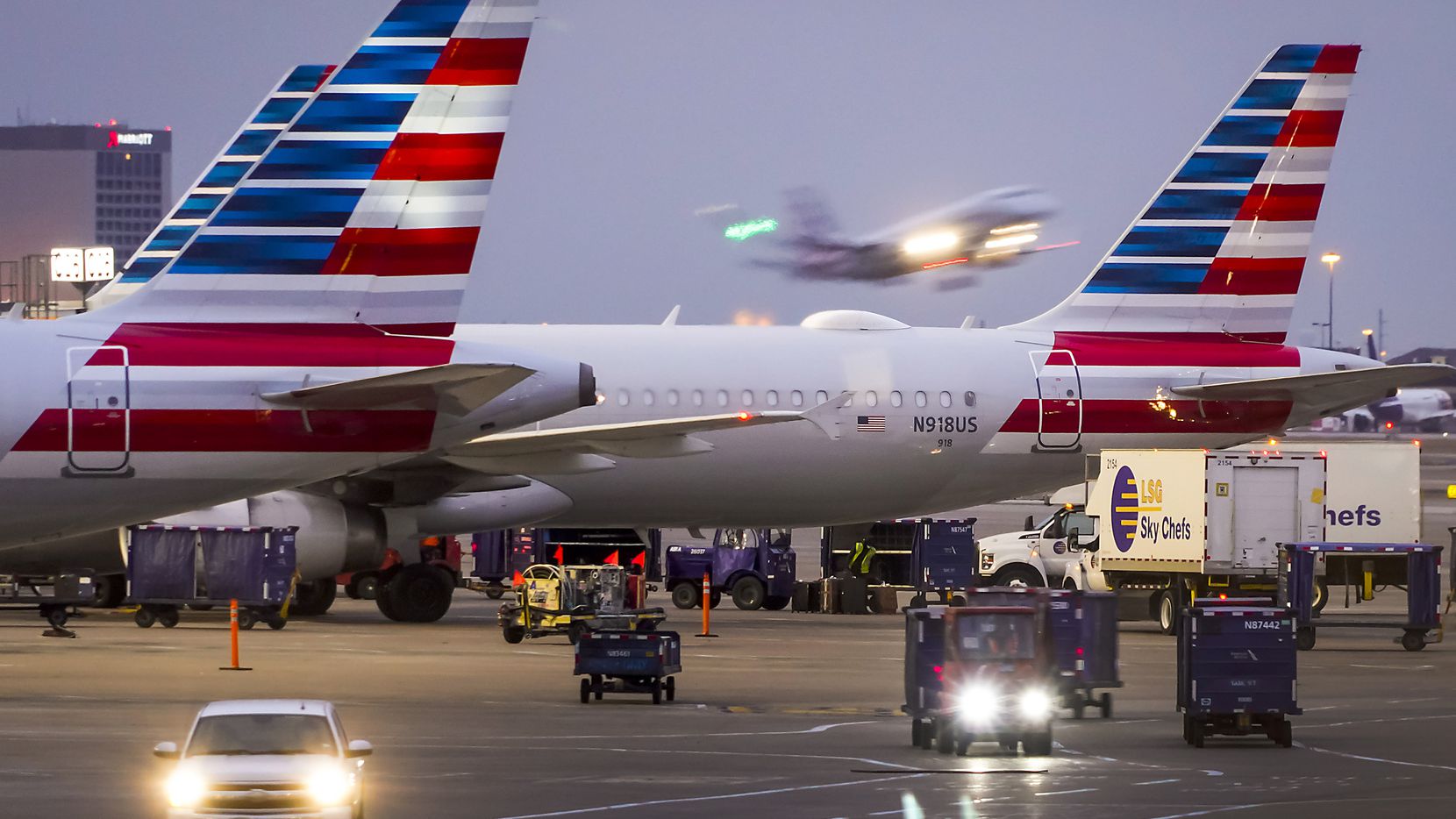American Airlines planes are seen at the gates of Terminal C as another American flight...