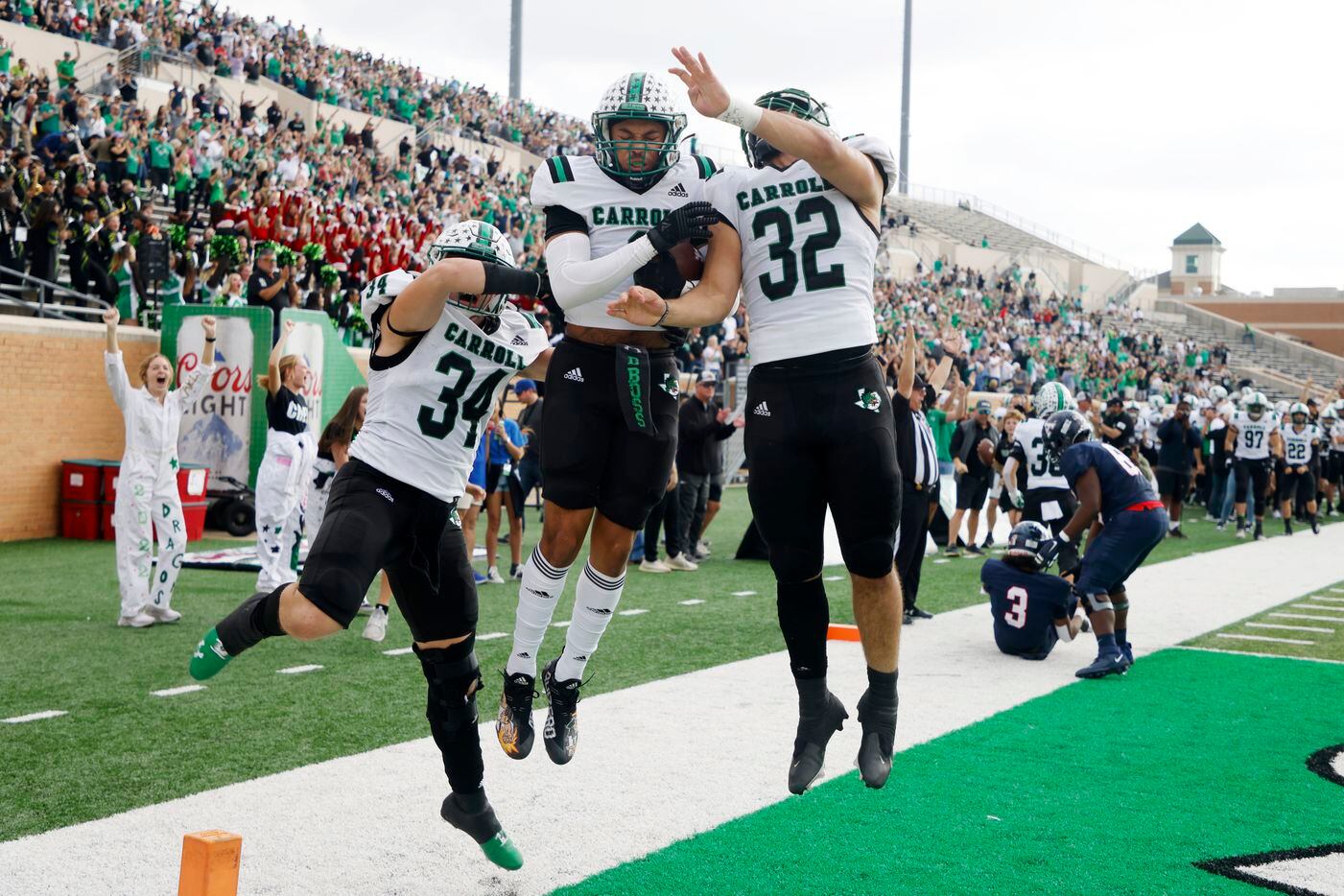 Southlake defendersTravis Keener (34) and Benecio Porras (32) celebrate with Avyonne Jones, center, after he scored a touchdown on an interception, against Allen during the first half of a Class 6A Division I Region I final high school football game in Denton, Texas on Saturday, Dec. 4, 2021. (Michael Ainsworth/Special Contributor)