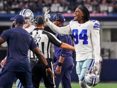 Officials and coaches try to keep Dallas Cowboys defensive end Randy Gregory (94) off the...