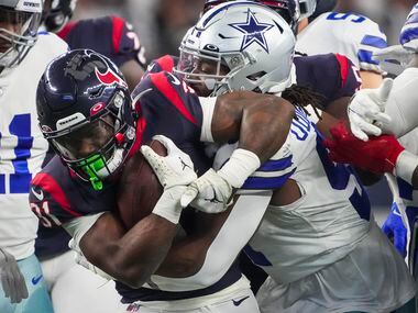 Houston Texans running back Dameon Pierce (31) is  brought down by Dallas Cowboys defensive...
