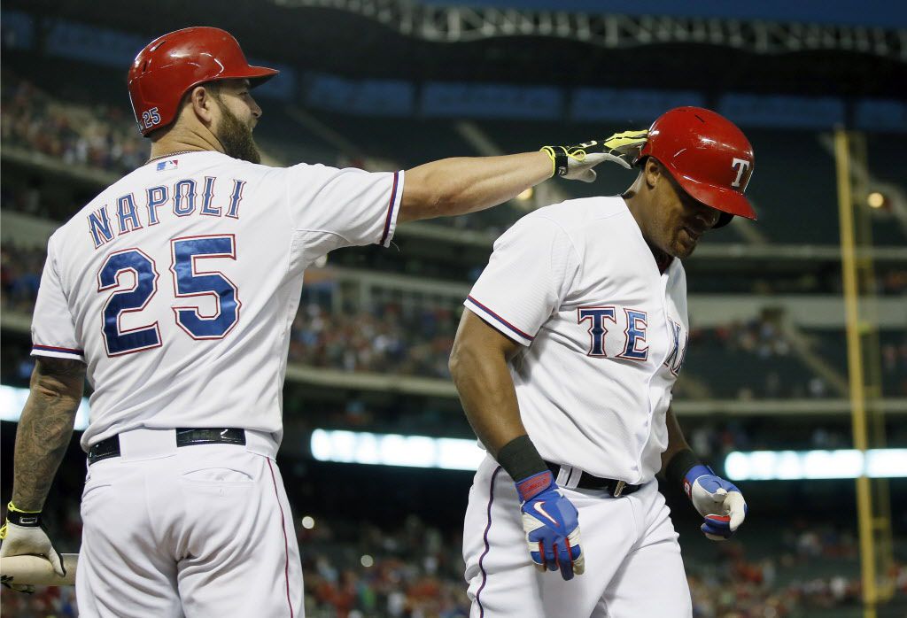 Texas Rangers' Mike Napoli (25) taps Adrian Beltre on the head following his two-run home...