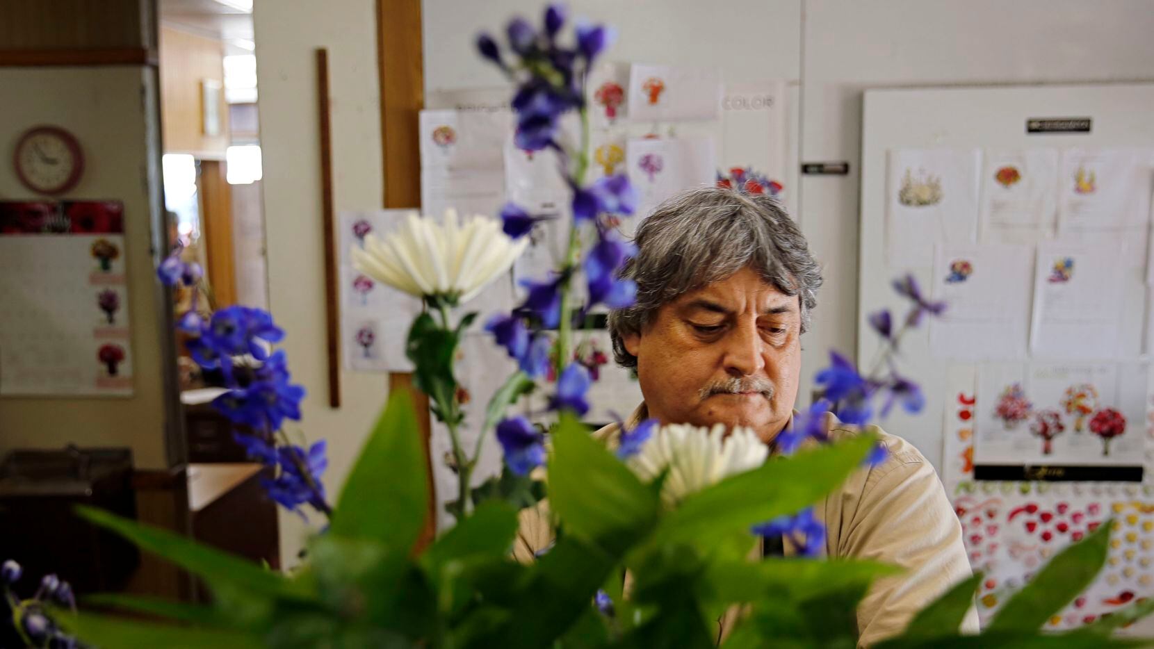 Joe Aguilar, co-owner and designer at Dallas House of Flowers, preps a burial wreath in...