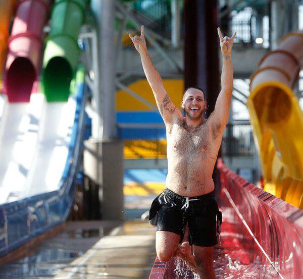 Tyler Hebert celebrates after going down a water slide at Epic Waters water park in Grand...