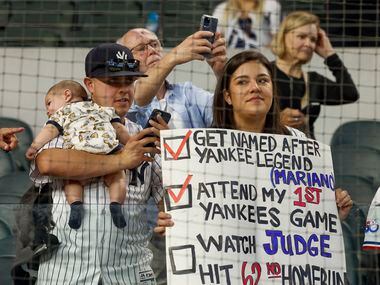 New York Yankees fans hold a sign before a MLB game against the Texas Rangers at Globe Life...