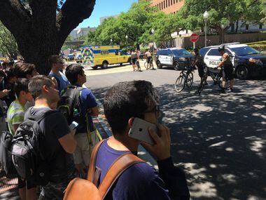 Students wait outside the scene where someone was fatally stabbed and others injured on the...