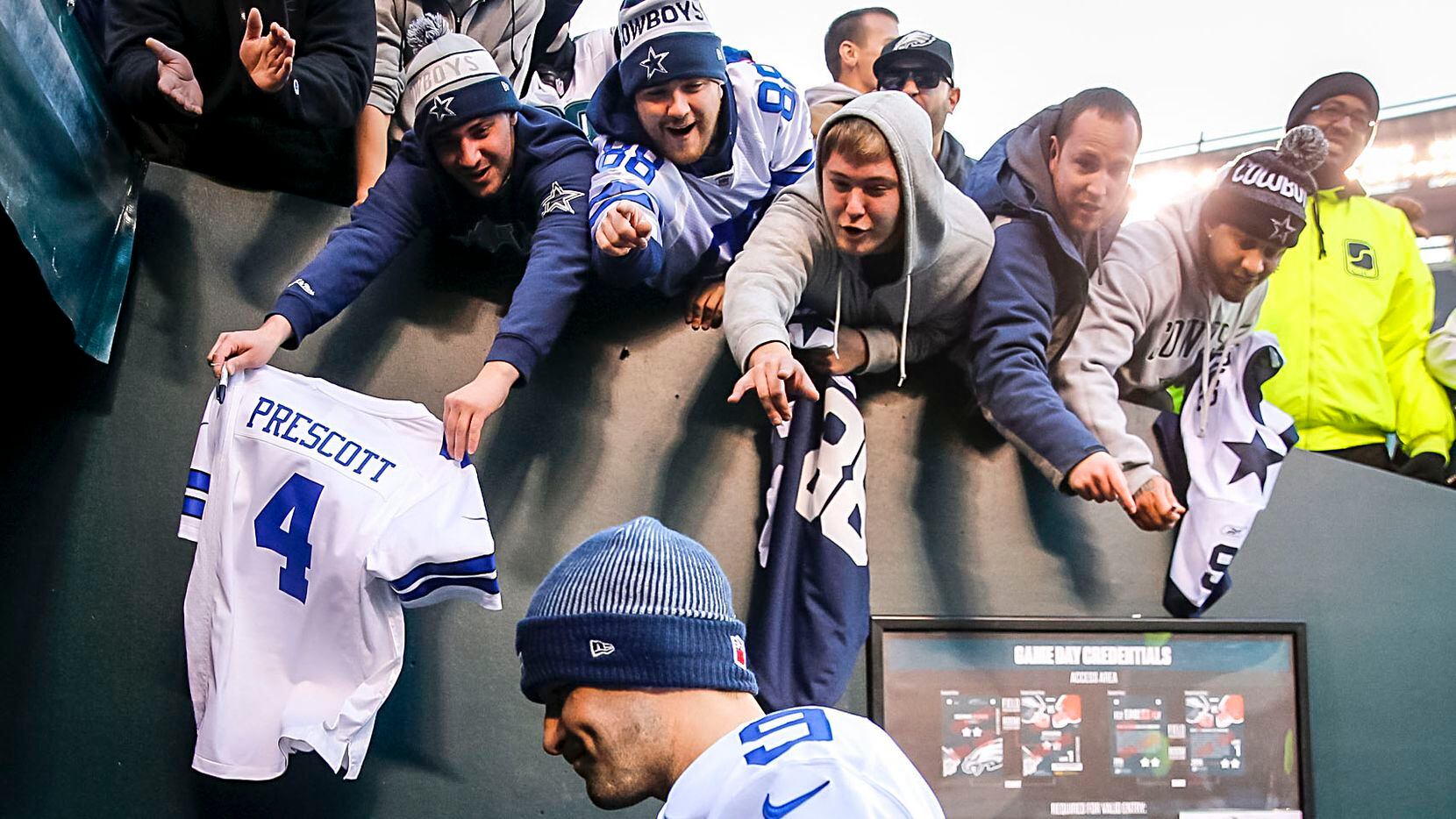 Fans yell to Dallas Cowboys quarterback Tony Romo as he walks off the field after a loss to...