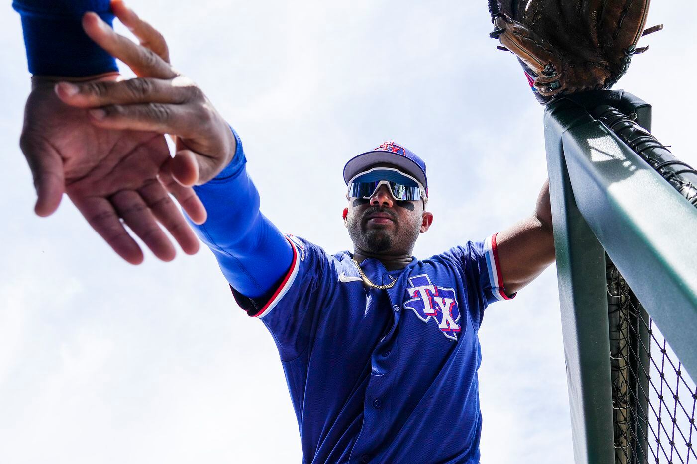 Texas Rangers infielder Andy Ibáñez slaps hands with a teammate before taking the field for...