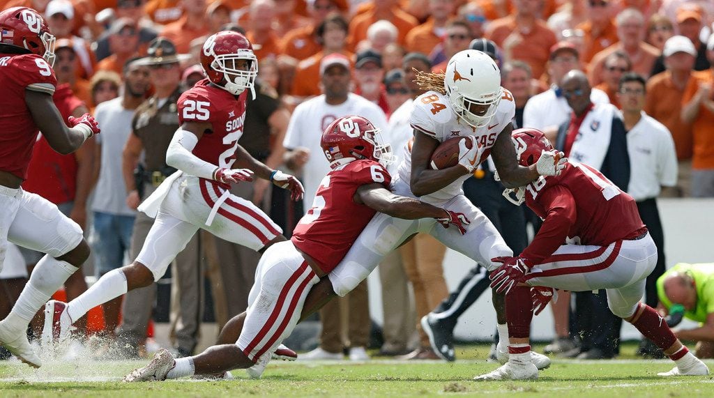 Texas Longhorns wide receiver Lil'Jordan Humphrey (84) is tackled by Oklahoma Sooners cornerback Tre Brown (6) and Oklahoma Sooners linebacker Curtis Bolton (18) during the second half of play at the Cotton Bowl in Dallas on Saturday, October 6, 2018. Texas Longhorns defeated Oklahoma Sooners 48-45. (Vernon Bryant/The Dallas Morning News)