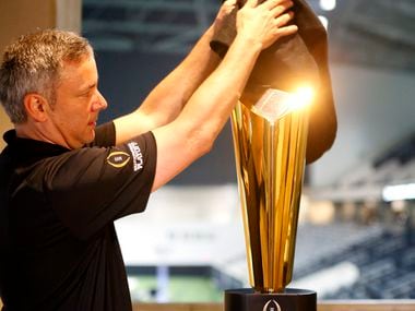 FILE - Trophy manager Charley Green sets up the national championship trophy during Big 12 football media days in the Ford Center at The Star in Frisco on Monday, July 17, 2017.