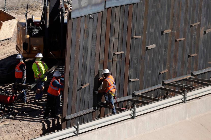 Trabajadores instalar barreras metálicas junto al Río Grande, en la frontera entre El Paso y...