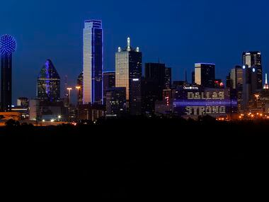 The Omni Dallas Hotel (right) reads "Dallas Strong" as the skyline of Dallas is aglow in...