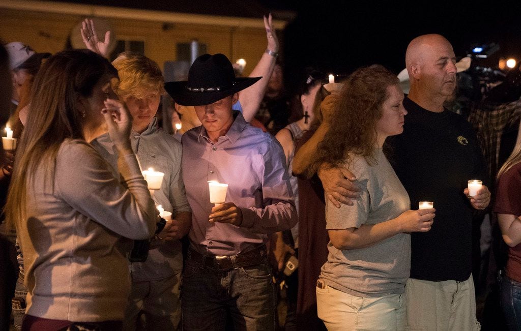 Mourners participate in a candlelight vigil held for the victims of a fatal shooting at the...