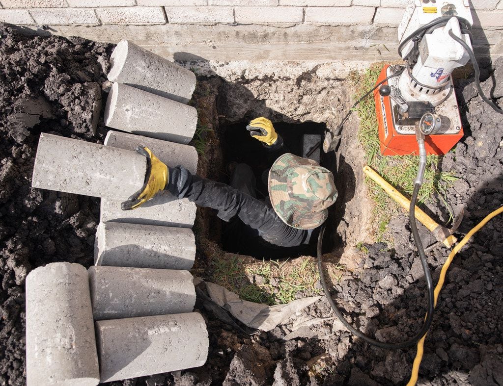 Ishmael Rangel, an employee with HD Foundations, reaches for another concrete piling that he...
