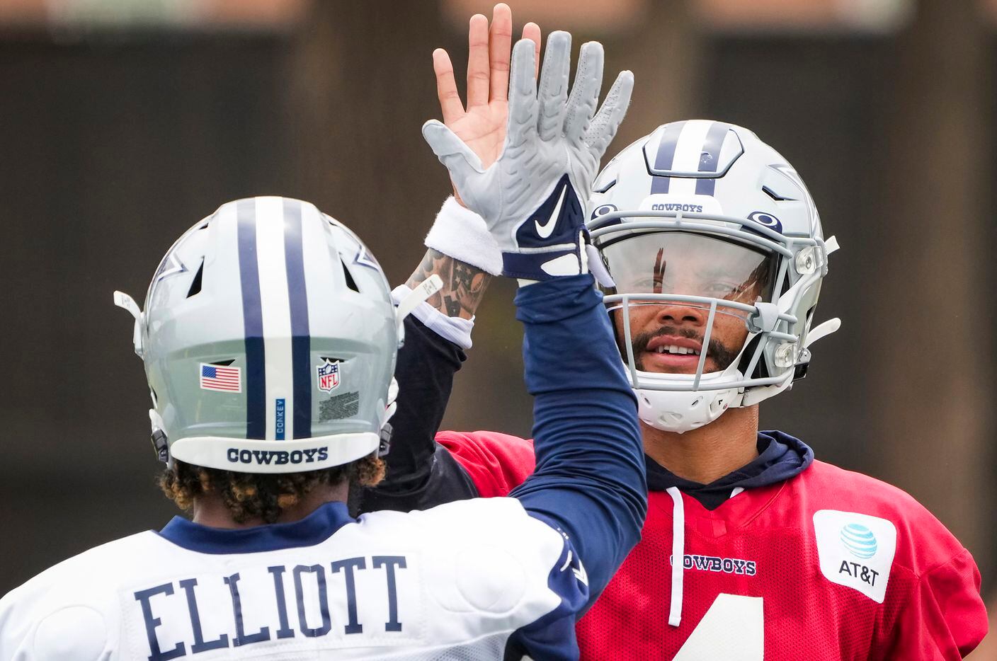 Dallas Cowboys quarterback Dak Prescott (4) high fives running back Ezekiel Elliott (21)...