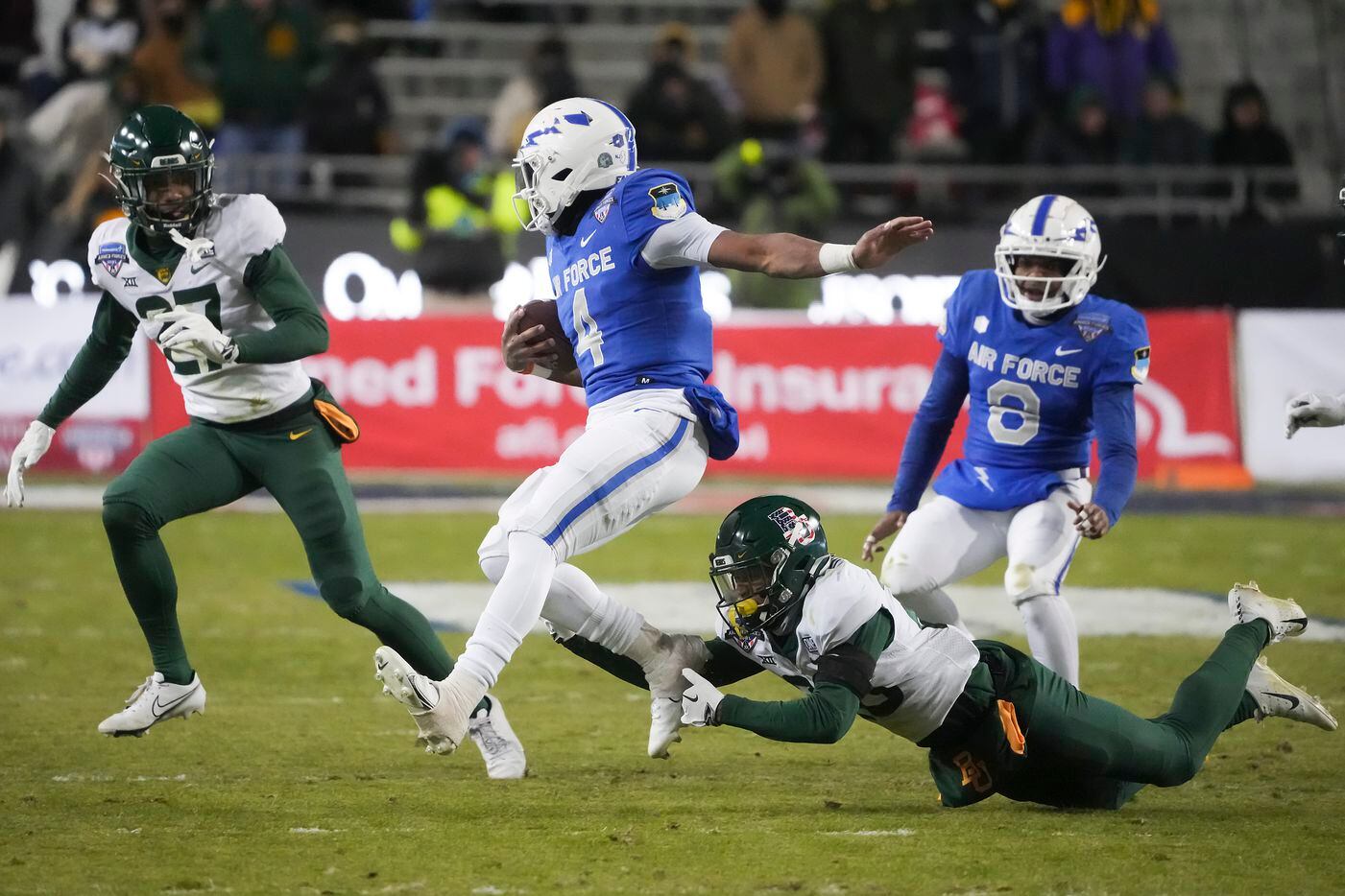 Air Force quarterback Haaziq Daniels (4) is tripped up by Baylor safety Devin Lemear (20)...