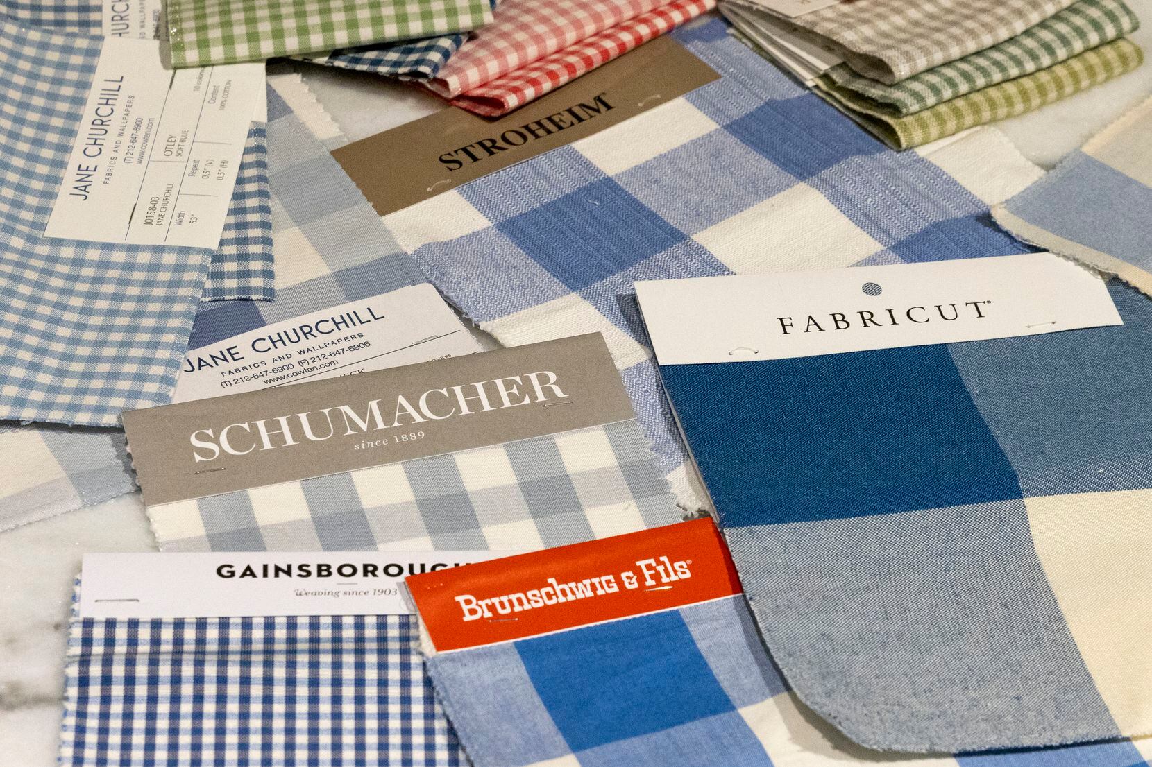 Blue and white checkered fabric samples from various manufacturers are available at Coco & Dash and other furniture stores. 
