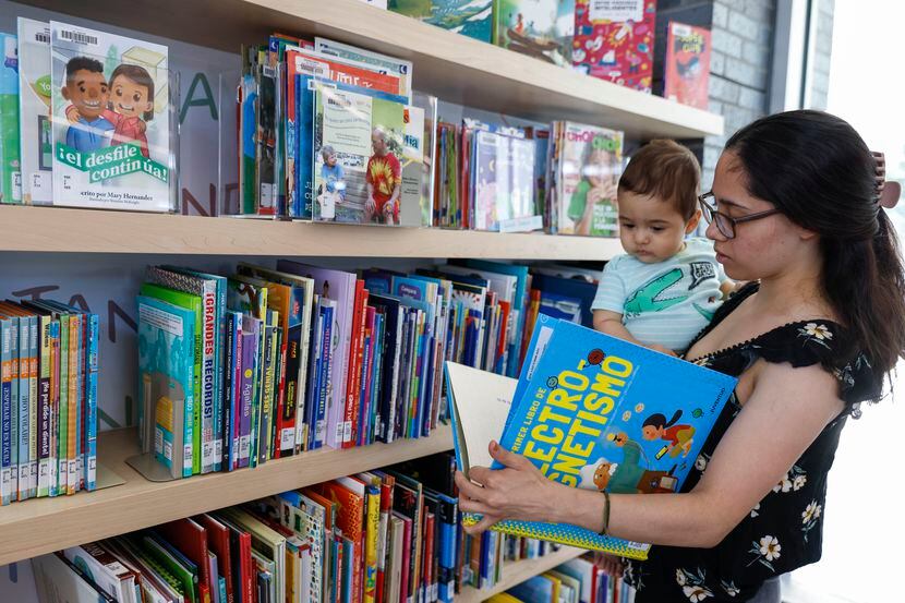 Dana Centeno le muestra un libro en español a su bebé de 8 meses, Nicholas, en la biblioteca...