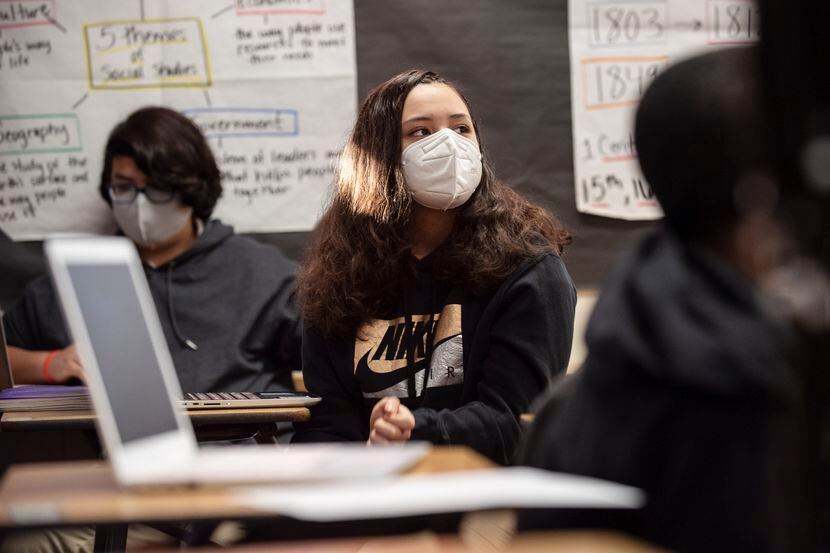 Eighth grader Yarettzi Chavez wears a face mask as she participates during a class...