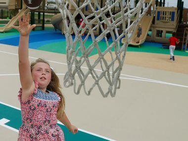 Adyson Jolley, 8, tosses a football into basketball net will playing on the Children's...