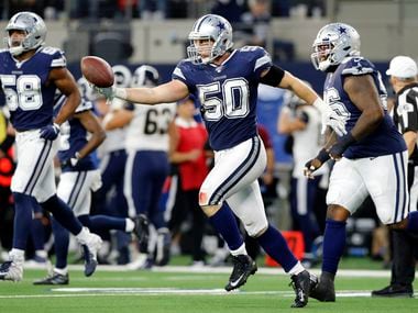 FILE — Dallas Cowboys outside linebacker Sean Lee (50) extends his arm to hand quarterback Dak Prescott (not pictured) the ball after making an interception at AT&T Stadium in Arlington, Texas, Sunday, December 15, 2019.