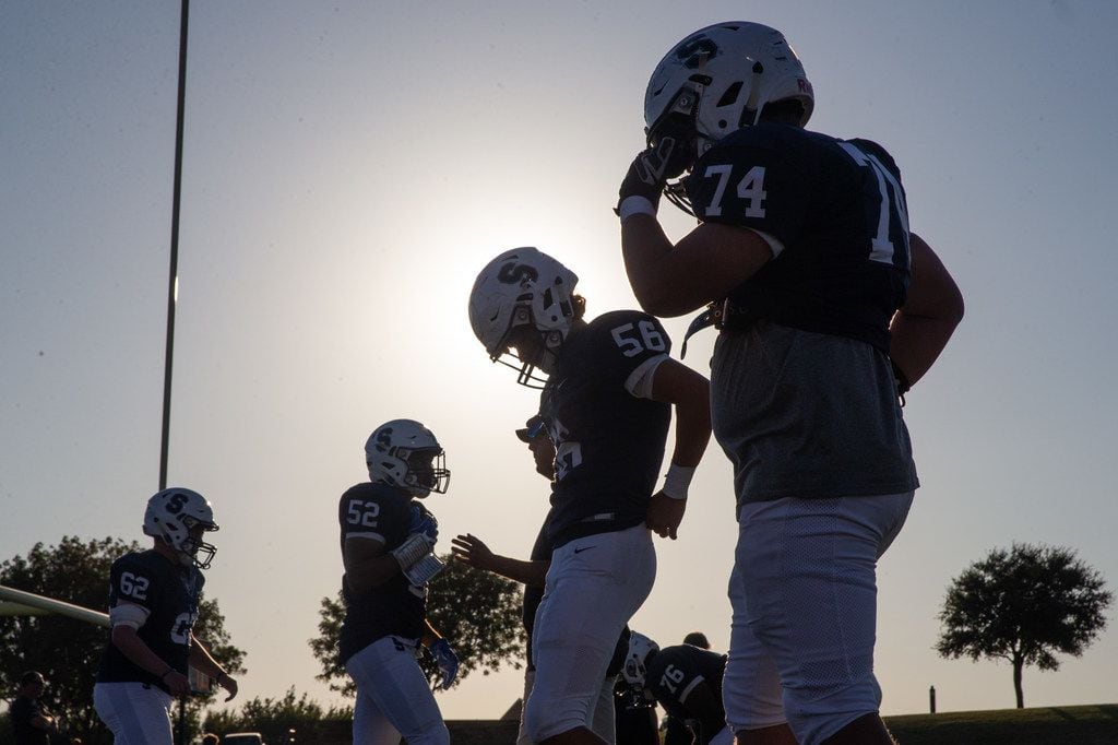 The sun begins to set behind the All Saints' Episcopal School varsity football team as they prepare for a game against Bishop Dunne Catholic School at Young Field McNair Stadium in Fort Worth, Texas, on Friday, Sep. 27, 2019. (Lynda M. Gonzalez/The Dallas Morning News)