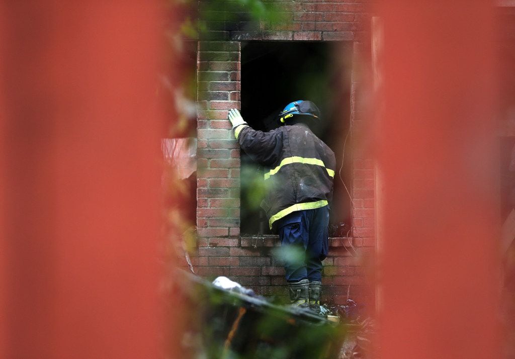 A Dallas County Fire Marshal peers into a house that caught fire early Thursday morning....