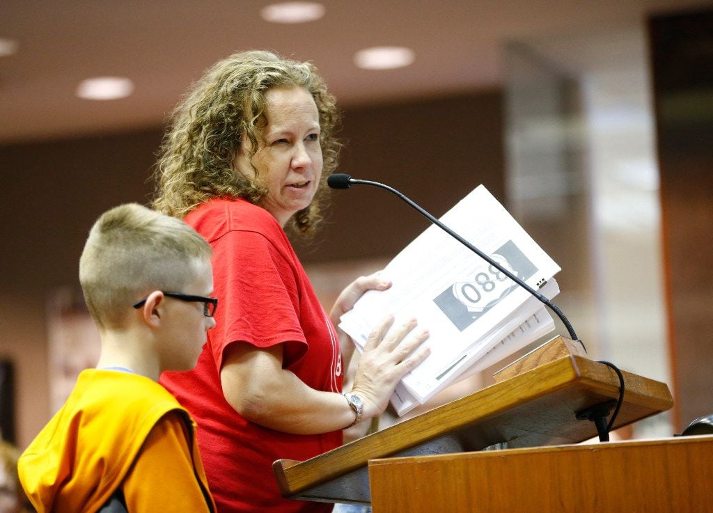 Tracy Thomas (right) with her son Hudson Thomas submits a petition opposed to a U.S. Highway 380 bypass during a McKinney City Council meeting on July 18, 2017.  