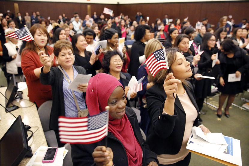 Fatimah Oritola of Nigeria (foreground) of Nigeria and others wave U.S. flags after reciting...