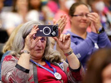 A woman records Texas Attorney General challenger Rochelle Garza speaking during the Lady...