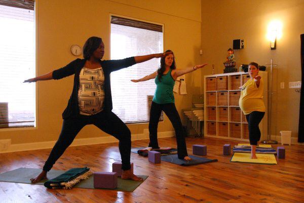 From left: Shakira Gbetibouo, 34, 32 weeks pregnant, Tamra Pierce, 29, 18 weeks pregnant, and Lisa Stropnicky, 27, 9 months pregnant, during a strong, confident, peaceful, warrior mama pose at a prenatal yoga class, on March 15, 2012, at the Pranaa yoga studio in Plano.