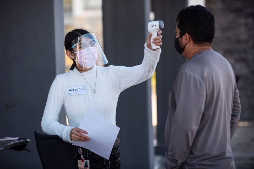 Una enfermera toma la temperatura a un paciente en Los Barrios Unidos en Dallas. El 15 de...