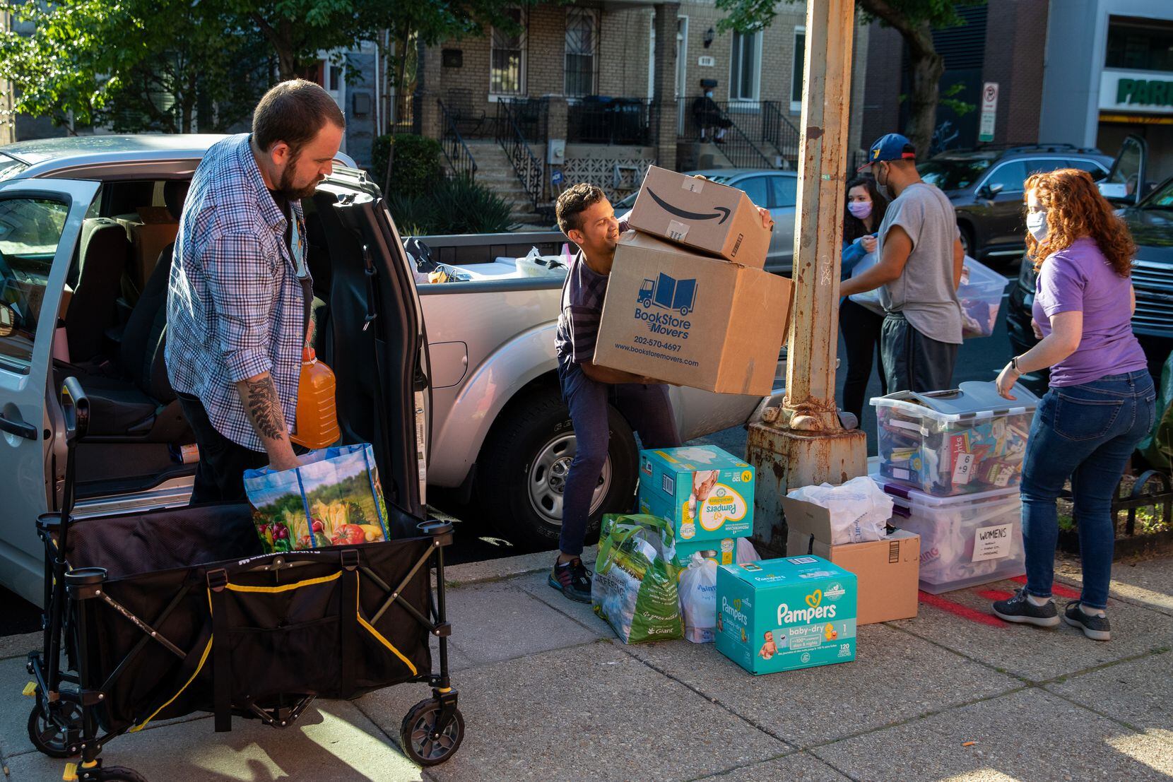 Volunteers with mutual aid groups, church organizations and migrants move supplies into...