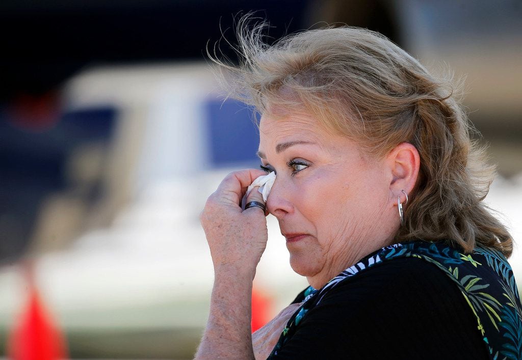 Christi Crawford wipes away tears as she watches the remains of her uncle, Marine Corps Pfc....