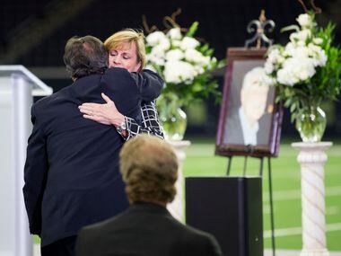 Robin Fry, daughter of Hayden Fry, gets a hug from a loved one after speaking during a...