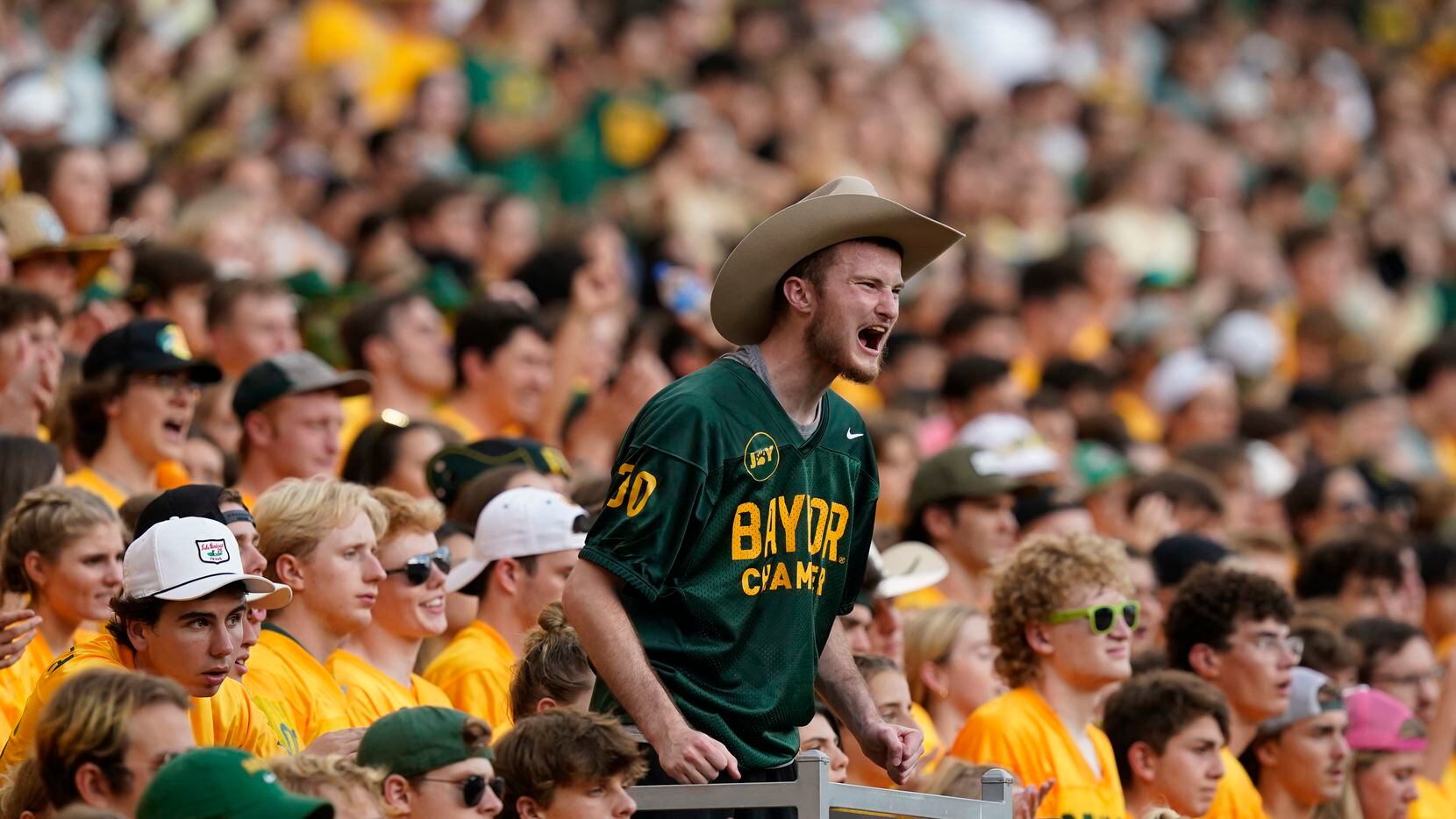 A fan yells from the stands during the first half of an NCAA college football game between...