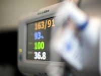 A patient's vital signs are displayed on a monitor at a hospital.