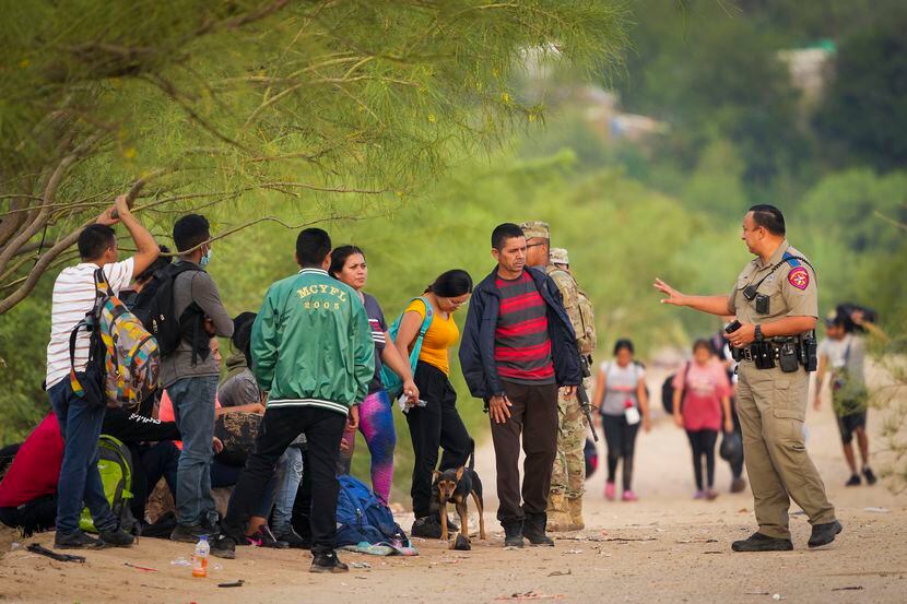 A Texas Department of Public Safety trooper talked to a group of migrants who turned...